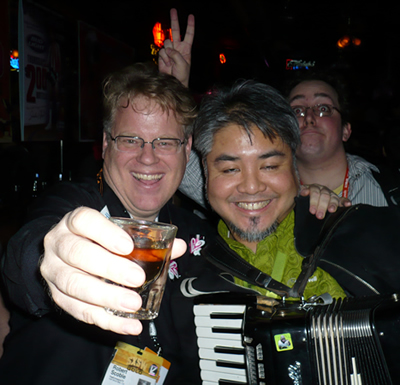 Robert Scoble (holding a shotglass) and a drunk Joey deVilla (holding an accordion)