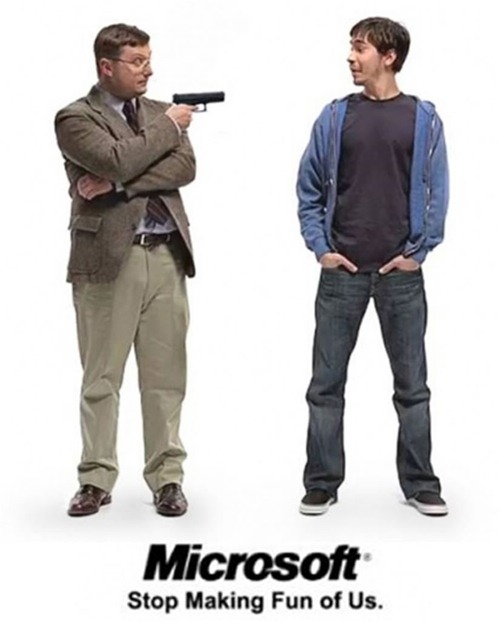 "I'm a PC" guy holding a gun pointed at "I'm a Mac" guy: "Microsoft: Stop making fun of us."