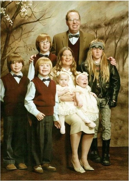 Family photo with everyone in the Sunday best, except for a son wearing metal/biker gear.