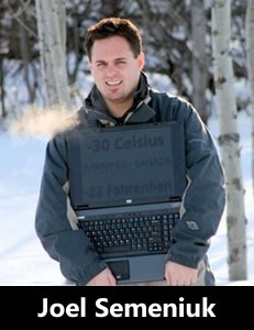 Photo of Joel Semeniuk standing outside with his laptop on a very cold winter day