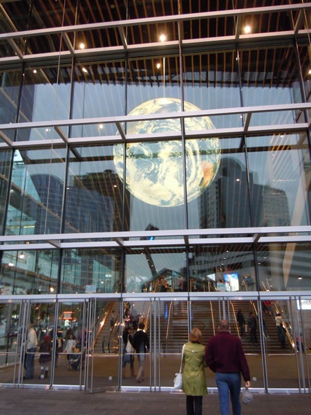 Burrard Street doors to Vancouver Convention Centre's West Building, with the giant globe hanging from the ceiling visible through the glass walls