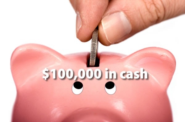 $100,000 in cash: close-up of a hand putting a coin in a piggy bank