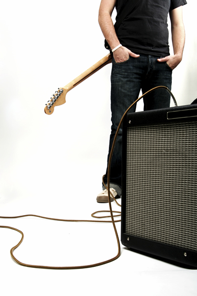 Neck-down shot of a guy with guitar and amp