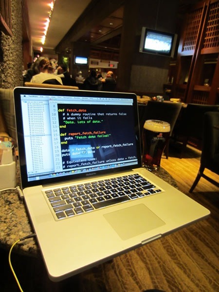Joey deVilla's MacBook Pro displaying Ruby code. A pint glass of Rickard's Red is beside it.