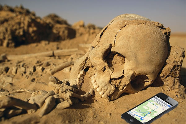 Skeleton in the desert beside an iPhone displaying Apple Maps