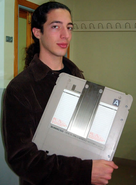 Guy holding an optical disk cartridge in his arm like a book