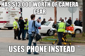 Photojournalist taking photo at the scene of an F-18 crash. She has lots of expensive camera equipment with her, but she's shooting a picture with her iPhone. Caption: "Has $13,000 of camera equipment / Uses phone instead"