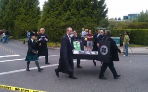 Pallbearers in Windows Phone garb carrying a "dead" iPhone