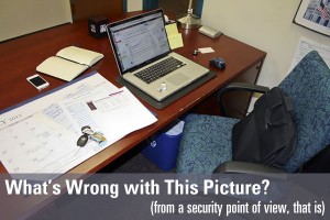 Typical office desk with a laptop, smartphone, keys and laptop bag on it - "What's wrong with this picture? (From a security point of view)"